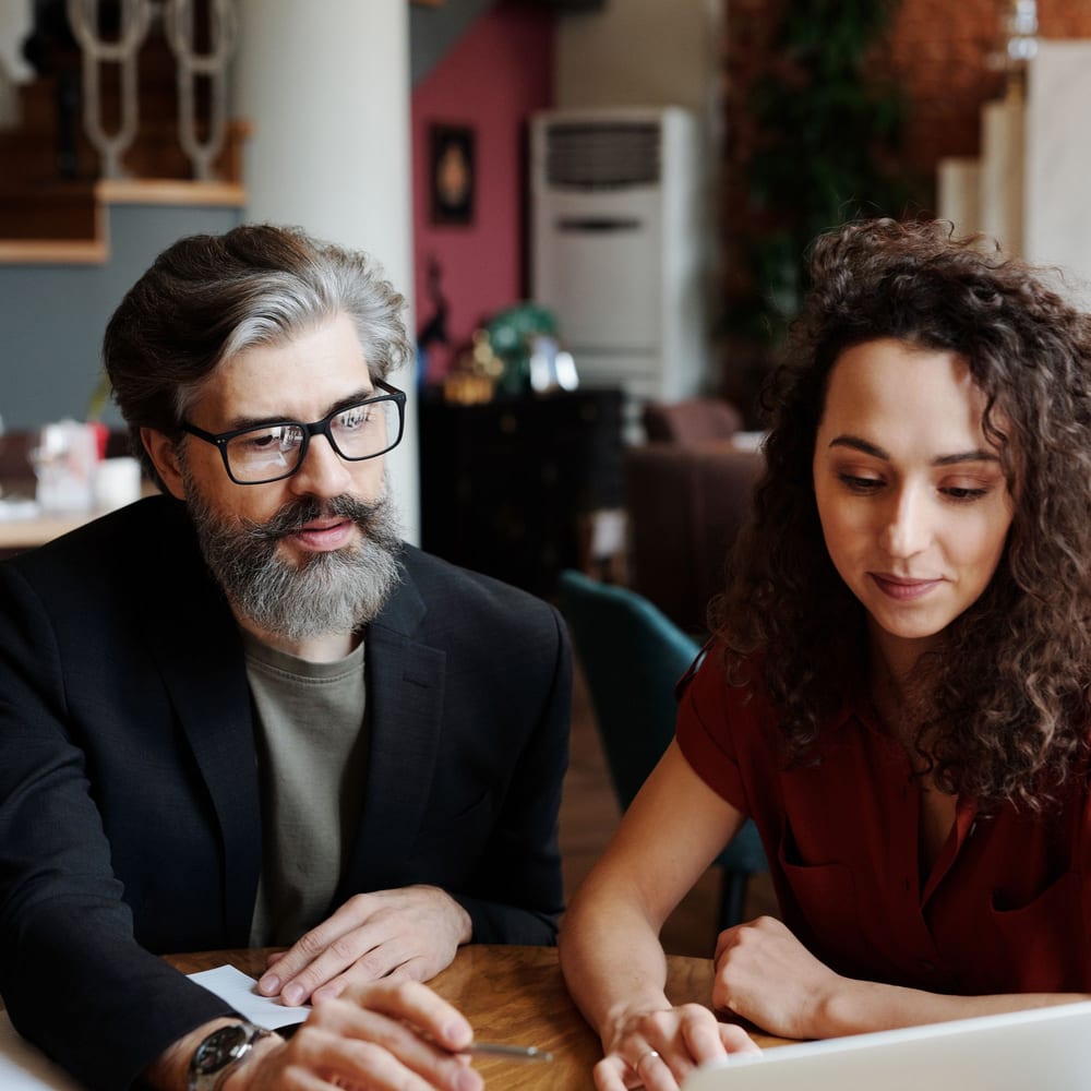 Two colleagues reviewing something on a laptop together